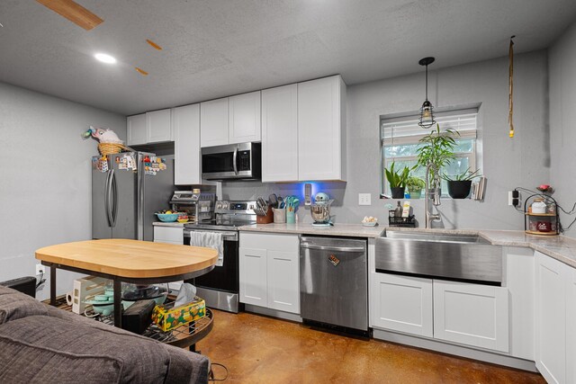 14293 S Fm 372, Valley View, TX 76272 - kitchen with appliances with stainless steel finishes, light countertops, a sink, concrete floors, and white cabinets