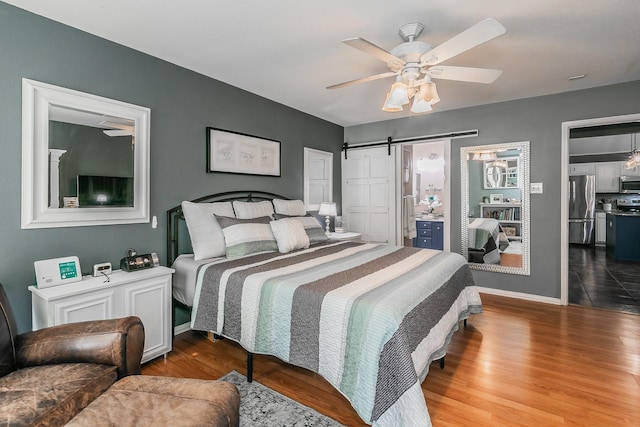 717 Kim Ln, Royse City, TX 75189 - bedroom featuring freestanding refrigerator, a barn door, wood finished floors, baseboards, and ceiling fan