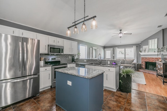 717 Kim Ln, Royse City, TX 75189 - kitchen with appliances with stainless steel finishes, a sink, vaulted ceiling, a peninsula, and a ceiling fan