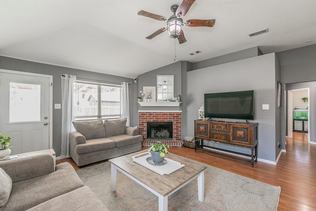 717 Kim Ln, Royse City, TX 75189 - living area featuring wood finished floors, ceiling fan, vaulted ceiling, a brick fireplace, and baseboards