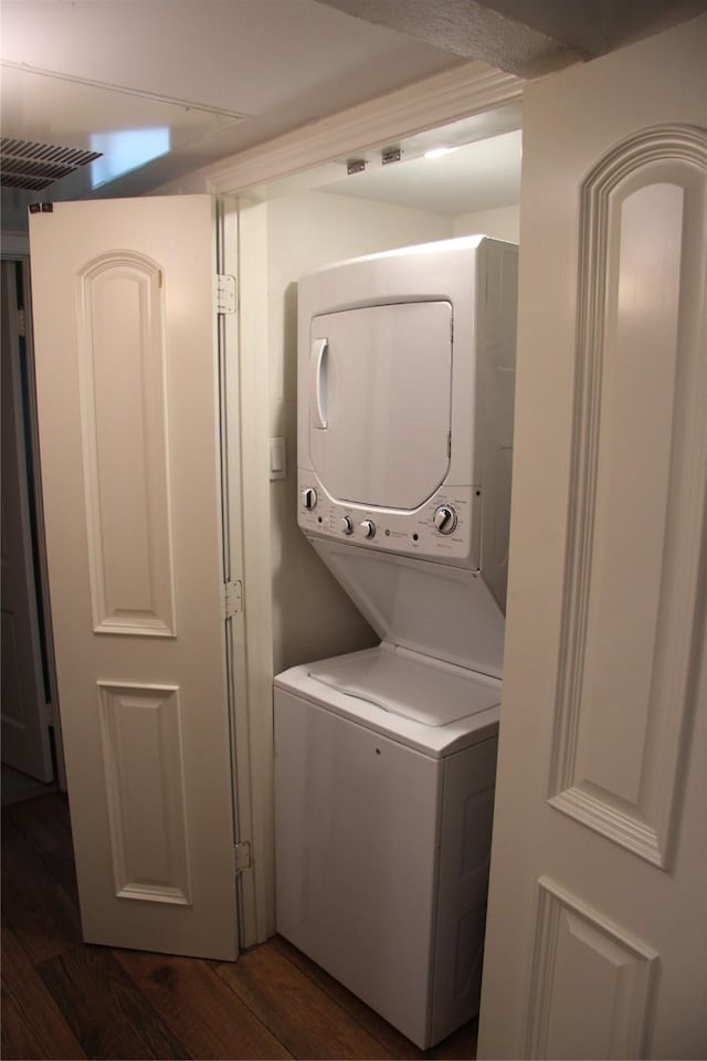 4320 Holland Ave Unit 202, Dallas, TX 75219 - washroom featuring stacked washer / dryer and dark wood-style floors