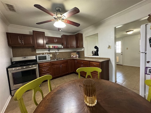 1206 S Crockett Dr, Abilene, TX 79605 - kitchen featuring stainless steel gas range, white microwave, light tile patterned floors, a sink, and ceiling fan