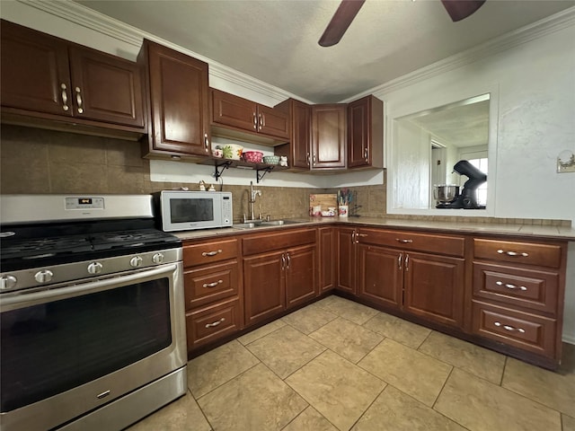 1206 S Crockett Dr, Abilene, TX 79605 - kitchen featuring stainless steel range with gas stovetop, white microwave, a ceiling fan, ornamental molding, and a sink