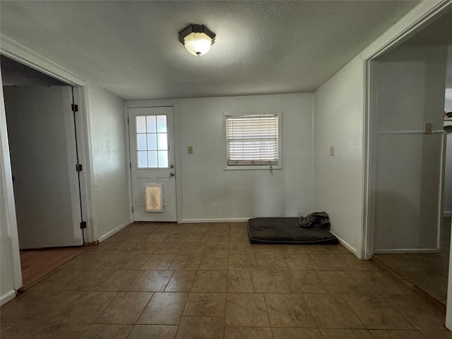1206 S Crockett Dr, Abilene, TX 79605 - doorway to outside featuring a textured ceiling, tile patterned flooring, and baseboards