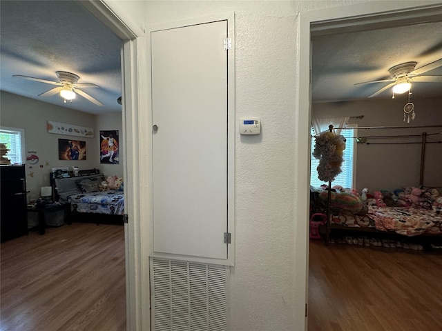 1206 S Crockett Dr, Abilene, TX 79605 - hallway with wood finished floors, a textured ceiling, and a textured wall