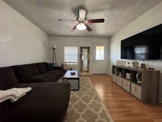 1206 S Crockett Dr, Abilene, TX 79605 - living area featuring light wood-style flooring, a textured ceiling, a ceiling fan, and baseboards