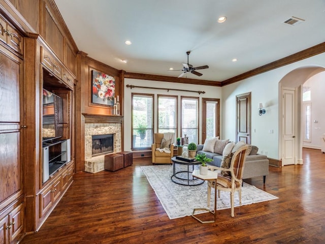 6609 Riverhill Dr, Plano, TX 75024 - living room with arched walkways, ornamental molding, recessed lighting, ceiling fan, and a fireplace with raised hearth