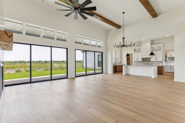 1324 Streetman Rd, Royse City, TX 75189 - unfurnished living room featuring beam ceiling, a high ceiling, light wood-style flooring, a chandelier, and ceiling fan