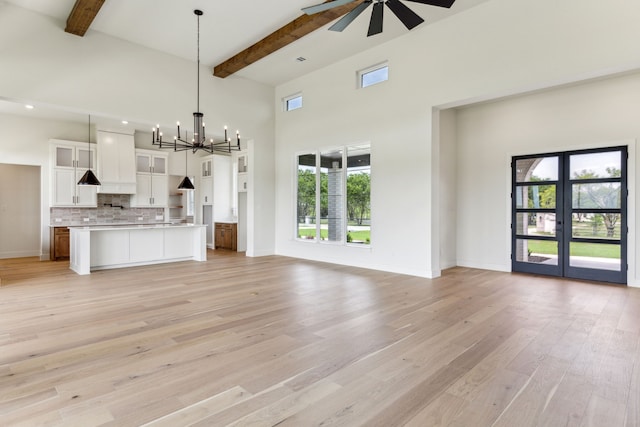 1324 Streetman Rd, Royse City, TX 75189 - unfurnished living room with beamed ceiling, a chandelier, a ceiling fan, light wood-type flooring, and a high ceiling