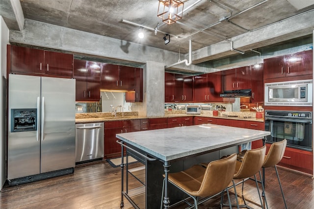 2011 Cedar Springs Rd Unit 106, Dallas, TX 75201 - kitchen with black appliances, dark wood-style floors, reddish brown cabinets, a sink, and range hood