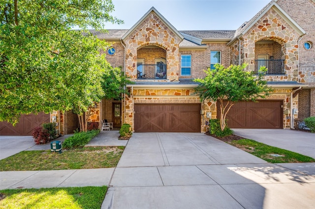 4220 Colton Dr, Carrollton, TX 75010 - view of front facade featuring stone siding, a balcony, a garage, and driveway