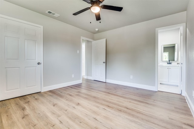 1326 Taperwicke Dr, Dallas, TX 75232 - unfurnished bedroom featuring light wood-style floors, baseboards, a sink, ensuite bathroom, and ceiling fan