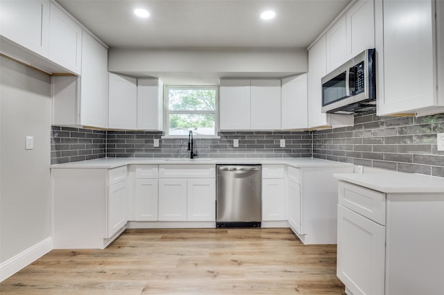 1326 Taperwicke Dr, Dallas, TX 75232 - kitchen with stainless steel appliances, a sink, tasteful backsplash, light wood finished floors, and recessed lighting