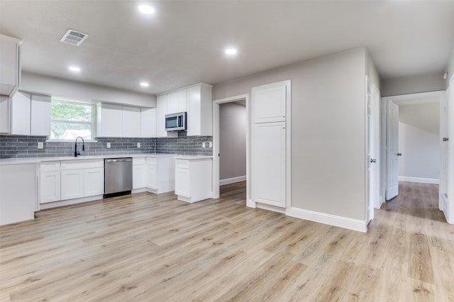 1326 Taperwicke Dr, Dallas, TX 75232 - kitchen featuring appliances with stainless steel finishes, a sink, decorative backsplash, light countertops, and recessed lighting