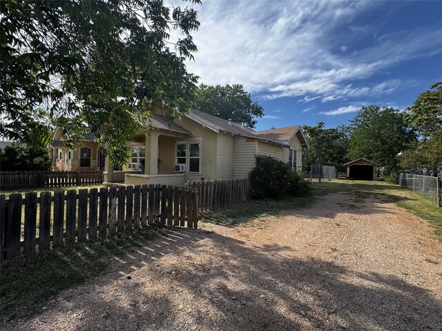2958 Russell Ave, Abilene, TX 79605 - view of side of property featuring dirt driveway, a carport, stucco siding, and an outdoor structure