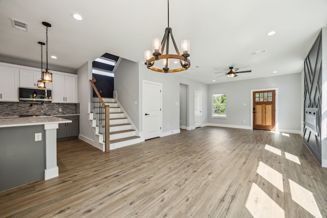 4002 Robert L Parish Sr Ave, Dallas, TX 75210 - unfurnished living room with a chandelier, stairway, recessed lighting, light wood-style floors, and baseboards