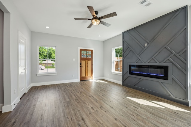 4002 Robert L Parish Sr Ave, Dallas, TX 75210 - unfurnished living room with a glass covered fireplace, healthy amount of natural light, wood finished floors, a ceiling fan, and recessed lighting