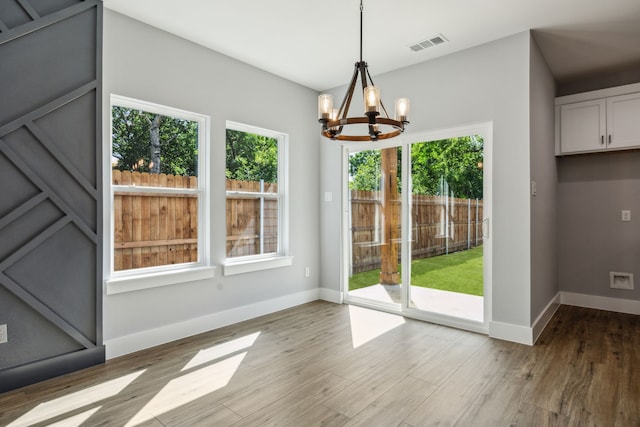 4002 Robert L Parish Sr Ave, Dallas, TX 75210 - unfurnished dining area with a chandelier, light wood-style flooring, and baseboards
