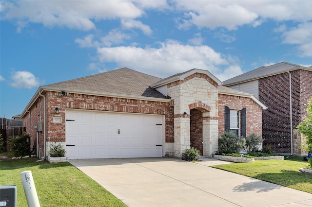 3125 Layla Creek Dr, Little Elm, TX 75068 - french country home with a front yard, concrete driveway, an attached garage, brick siding, and roof with shingles