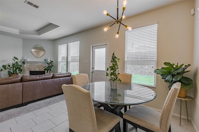 3125 Layla Creek Dr, Little Elm, TX 75068 - dining room with a chandelier, light tile patterned floors, a stone fireplace, and a raised ceiling
