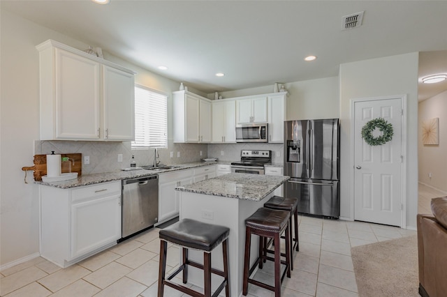 3125 Layla Creek Dr, Little Elm, TX 75068 - kitchen with appliances with stainless steel finishes, a sink, backsplash, white cabinets, and light stone countertops