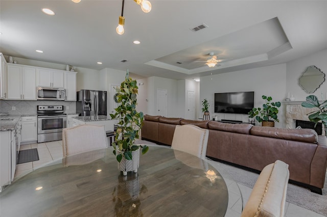 3125 Layla Creek Dr, Little Elm, TX 75068 - dining space with a raised ceiling, ceiling fan, light tile patterned floors, and recessed lighting