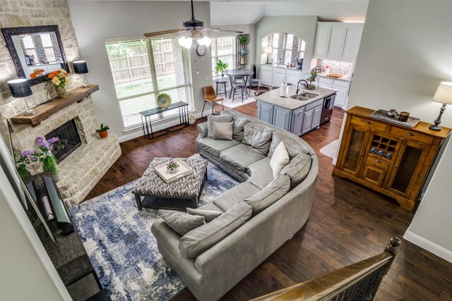921 Yarwood Way, Burleson, TX 76028 - living room with ceiling fan, vaulted ceiling, baseboards, dark wood-type flooring, and a stone fireplace