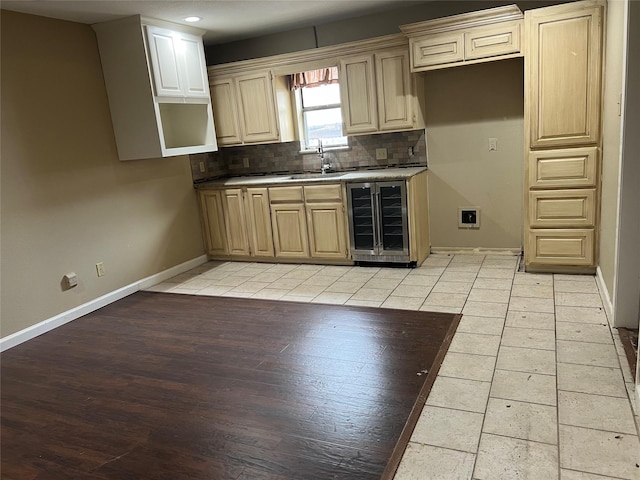 332 Belmont St, Hurst, TX 76053 - kitchen with beverage cooler, tasteful backsplash, a sink, light wood finished floors, and baseboards