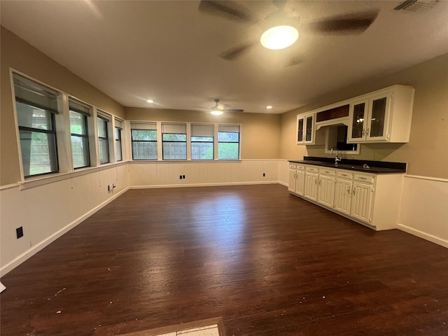 332 Belmont St, Hurst, TX 76053 - kitchen featuring ceiling fan, dark wood-type flooring, glass insert cabinets, dark countertops, and wainscoting