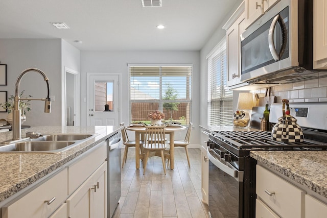 140 Orchard Pines Pl, Boyd, TX 76023 - kitchen featuring appliances with stainless steel finishes, a sink, backsplash, recessed lighting, and baseboards