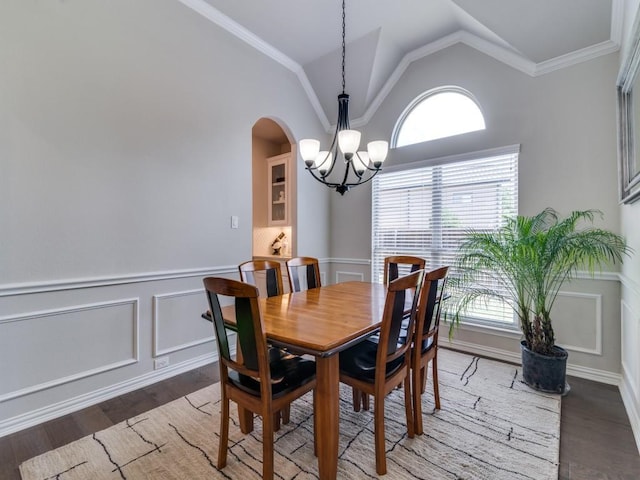 2201 Mountain Creek Ct, Wylie, TX 75098 - dining room featuring a chandelier, wood finished floors, arched walkways, a wainscoted wall, and lofted ceiling