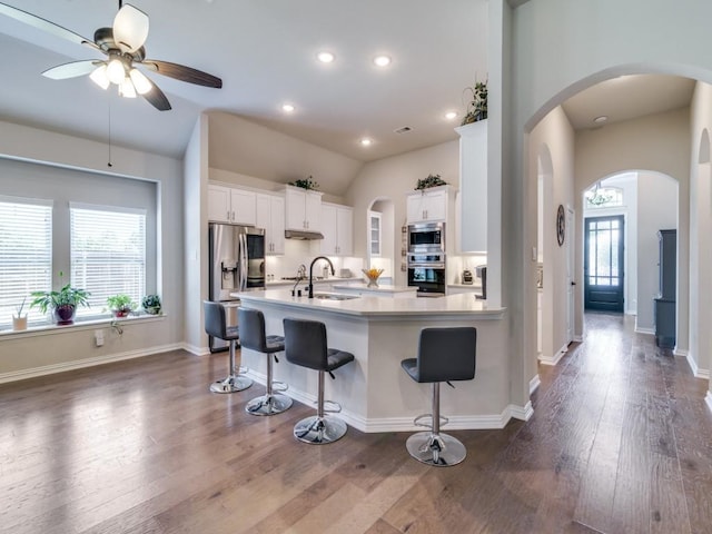 2201 Mountain Creek Ct, Wylie, TX 75098 - kitchen with stainless steel appliances, a sink, ceiling fan, white cabinetry, and a breakfast bar