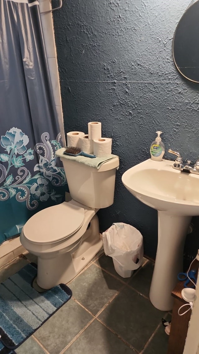 5612 Wainwright Dr, Fort Worth, TX 76112 - bathroom featuring tile patterned flooring, toilet, curtained shower, and a textured wall