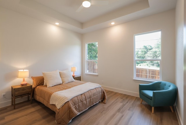 2836 Ave L, Fort Worth, TX 76105 - bedroom with light wood-style flooring, a tray ceiling, recessed lighting, baseboards, and a ceiling fan