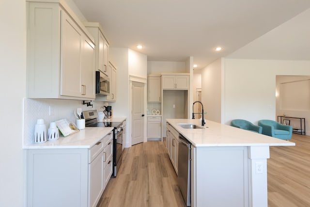 2836 Ave L, Fort Worth, TX 76105 - kitchen featuring appliances with stainless steel finishes, a sink, light wood-type flooring, recessed lighting, and a center island with sink