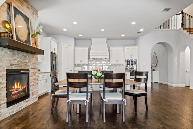 1020 Highpoint Way, Roanoke, TX 76262 - dining room with dark wood finished floors, a stone fireplace, stairs, recessed lighting, and baseboards