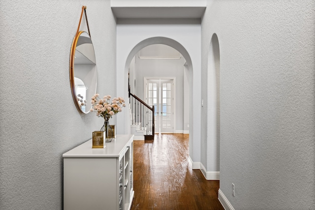 1020 Highpoint Way, Roanoke, TX 76262 - corridor with arched walkways, a textured wall, dark wood-type flooring, stairs, and baseboards