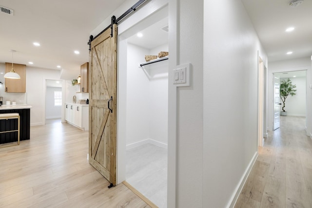 4128 Blackwillow Dr, Mesquite, TX 75150 - hallway featuring a barn door, light wood-style flooring, recessed lighting, and baseboards
