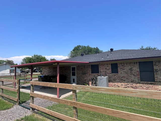609 S 3rd St, Sanger, TX 76266 - view of property exterior featuring cooling unit, brick siding, an exterior structure, and a shingled roof