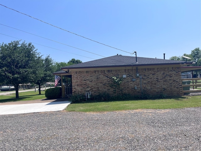 609 S 3rd St, Sanger, TX 76266 - view of side of property featuring brick siding, a yard, a shingled roof, and driveway