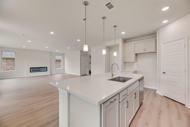 3229 Loftwood Ln, Anna, TX 75409 - kitchen with dishwasher, light wood-style flooring, recessed lighting, a kitchen island with sink, and light countertops