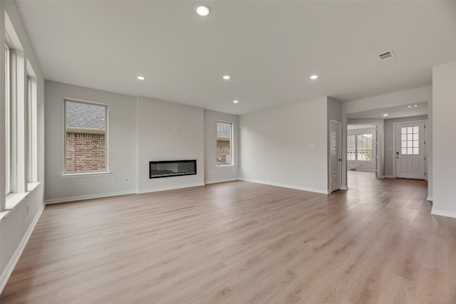 3229 Loftwood Ln, Anna, TX 75409 - unfurnished living room with recessed lighting, light wood-style floors, and a glass covered fireplace