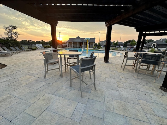 409 Hoover Ave, Lavon, TX 75166 - patio terrace at dusk featuring a pergola, a community pool, and a patio area