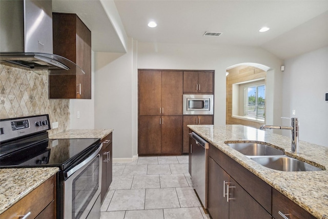 409 Hoover Ave, Lavon, TX 75166 - kitchen featuring wall chimney exhaust hood, stainless steel appliances, decorative backsplash, arched walkways, and lofted ceiling
