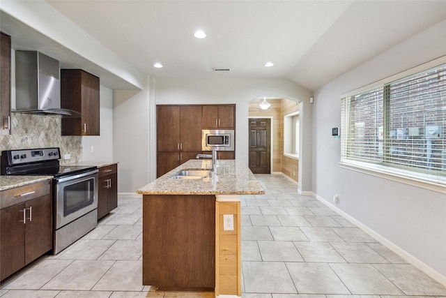 409 Hoover Ave, Lavon, TX 75166 - kitchen with stainless steel appliances, wall chimney exhaust hood, decorative backsplash, arched walkways, and vaulted ceiling