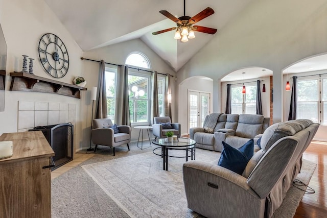 431 Lakefield Dr, Murphy, TX 75094 - tiled living area featuring arched walkways, ceiling fan, vaulted ceiling, and a tiled fireplace
