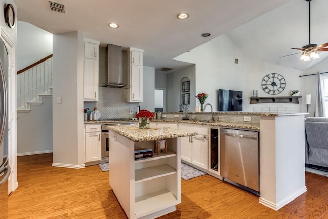 431 Lakefield Dr, Murphy, TX 75094 - kitchen with stainless steel dishwasher, wall chimney exhaust hood, a sink, light wood-type flooring, and white cabinetry