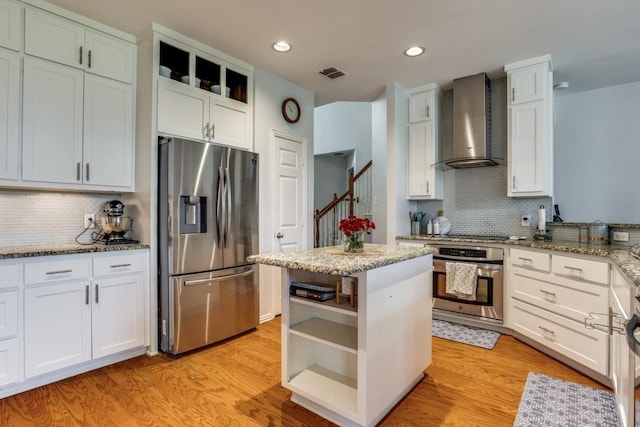 431 Lakefield Dr, Murphy, TX 75094 - kitchen with appliances with stainless steel finishes, wall chimney exhaust hood, open shelves, decorative backsplash, and light stone countertops