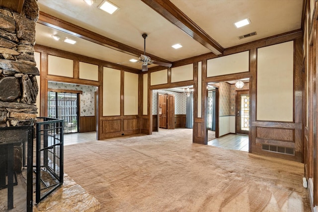 4001 Sonora Dr, Plano, TX 75074 - unfurnished living room featuring a decorative wall, light carpet, ceiling fan, beamed ceiling, and a wainscoted wall