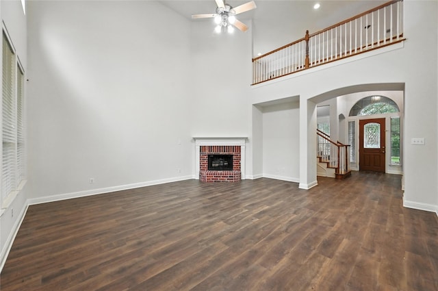 3816 Appleton Ln, Flower Mound, TX 75022 - unfurnished living room featuring a high ceiling, dark wood finished floors, arched walkways, ceiling fan, and a fireplace